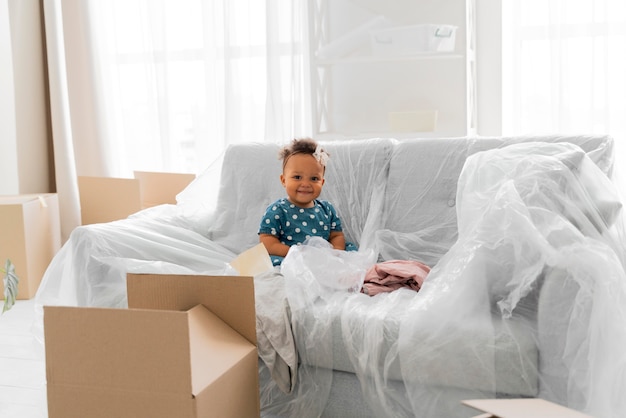 Free photo adorable baby girl sitting in her old house before moving out