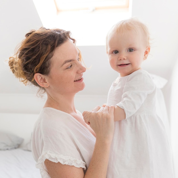 Free photo adorable baby girl together with mother at home