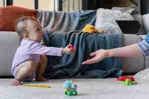 Free photo adorable baby handing a toy to his mother