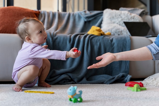 Adorable baby handing a toy to his mother