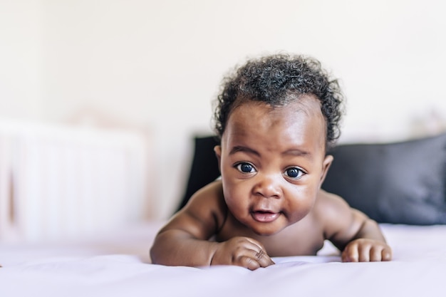 Adorable baby lying in bed and smiling