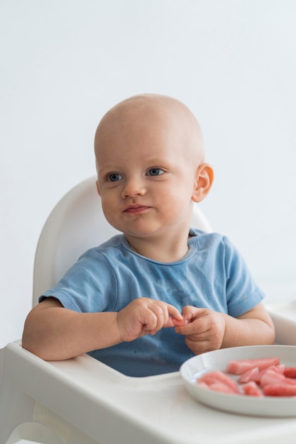 Free photo adorable baby playing with food