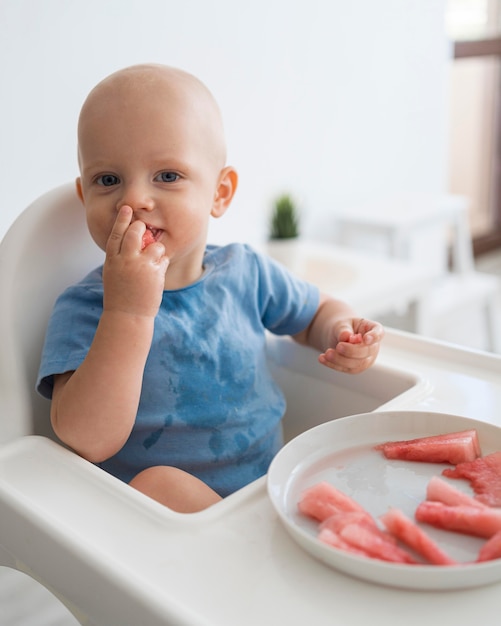 Adorable baby playing with food