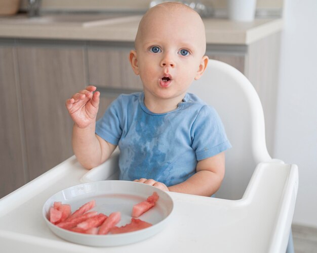 Adorable baby playing with food