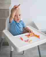 Free photo adorable baby playing with food