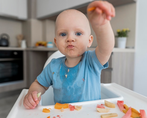 Adorable baby playing with food