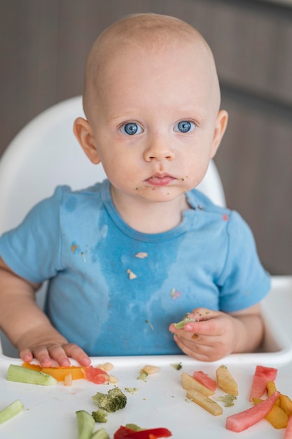 Adorable baby playing with food