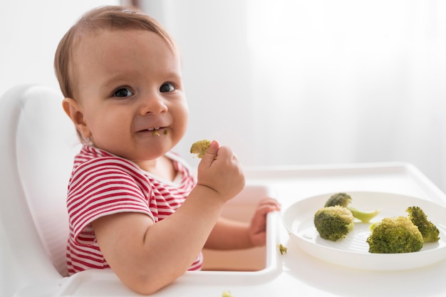 Adorable baby playing with food