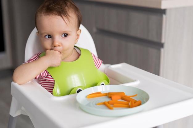 Adorable baby playing with food