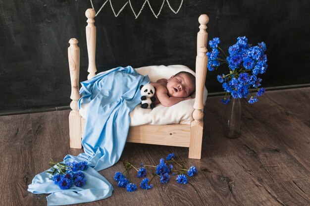 Adorable baby in small bed