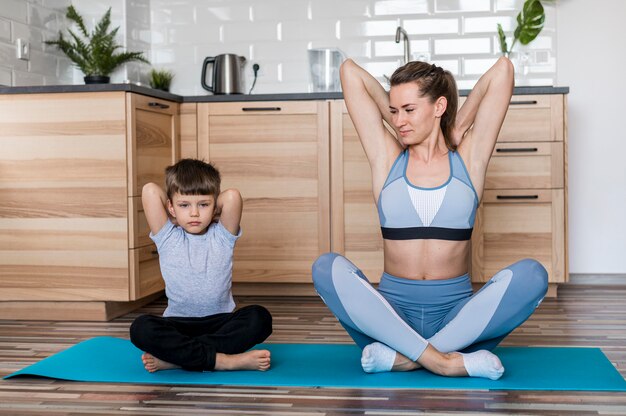 Adorable boy training together with his mom