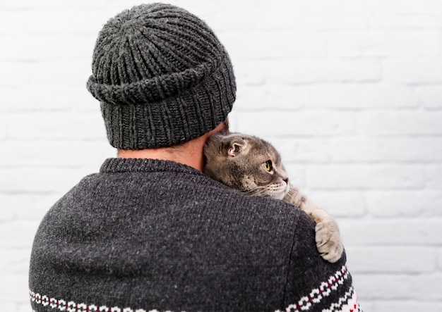 Free photo adorable cat held by owner