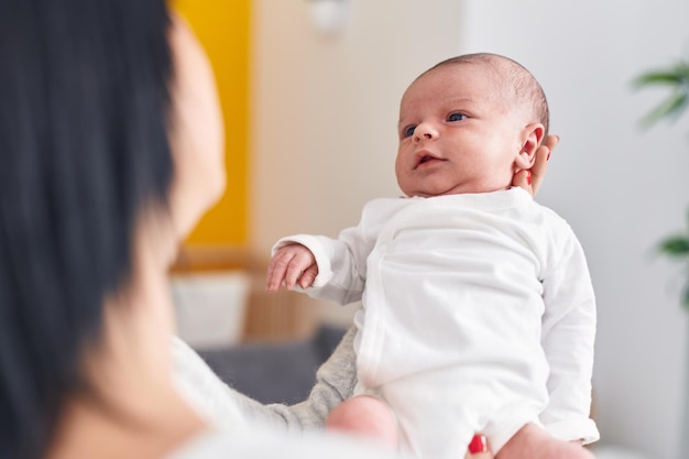 Adorable caucasian baby on mother hands at home