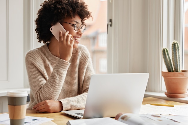 Free photo adorable cheerful young lady working at home