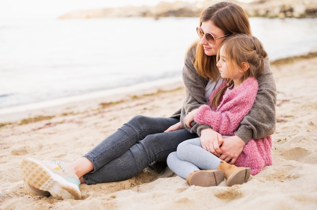 Foto gratuita bambino adorabile e madre che abbracciano all'aperto