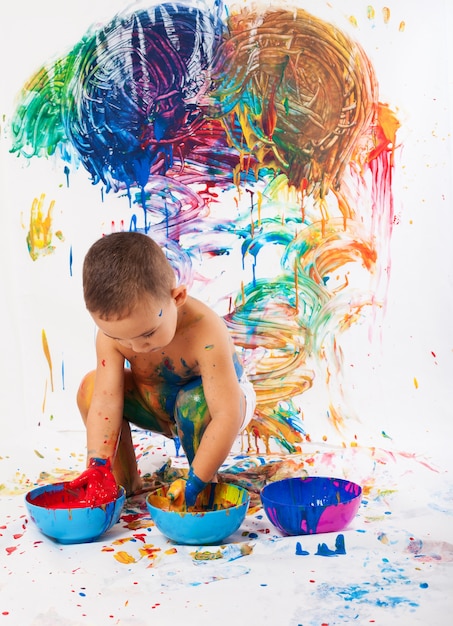 Adorable child playing with paints