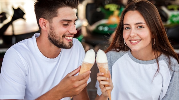 Adorable couple holding ice creams at fair