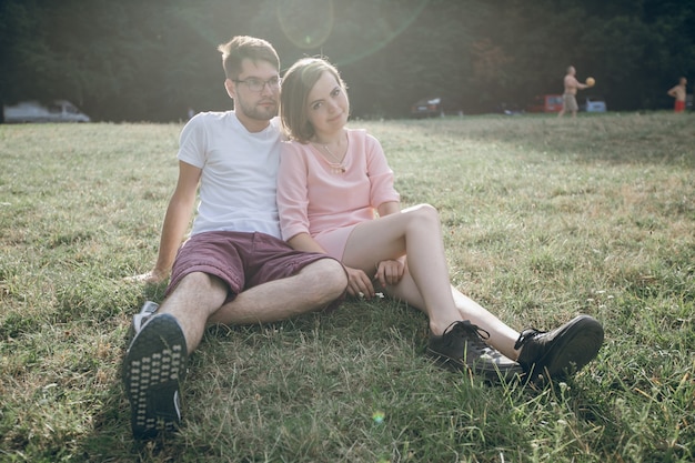 Adorable couple sitting together on the lawn of a park