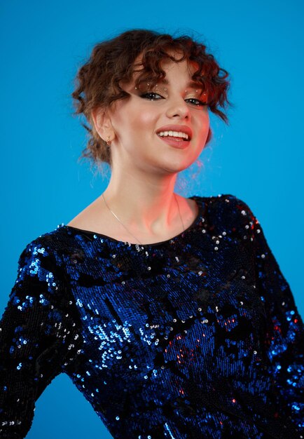 Adorable curlyhaired girl on blue background High quality photo