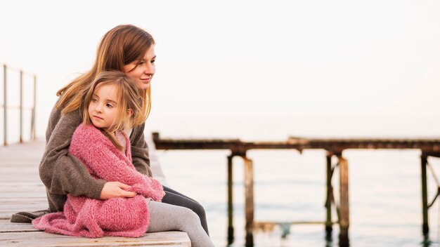 Adorable daughter and mother sitting