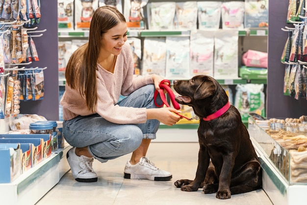 ペットショップで女性の飼い主と愛らしい犬