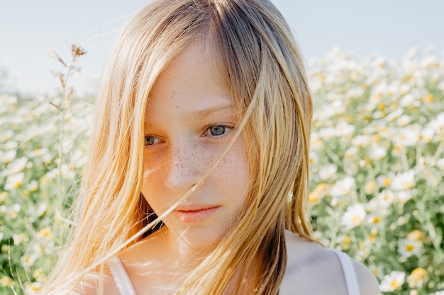 Adorable girl in chamomile field