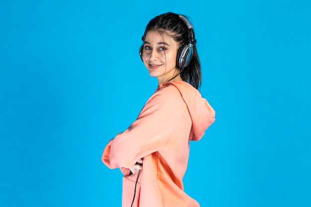 Adorable girl cross her arms and standing on blue background