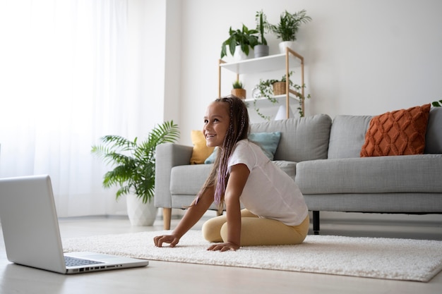 Adorable girl doing yoga at home