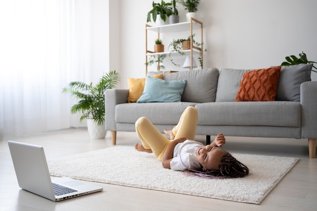 Adorabile ragazza che fa yoga a casa