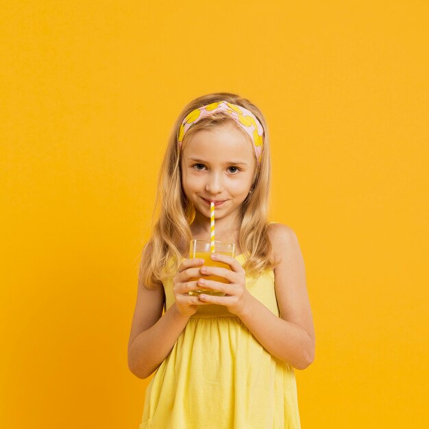 ストローでレモネードを飲む愛らしい少女