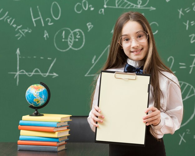 Adorable girl holding empty clipboard