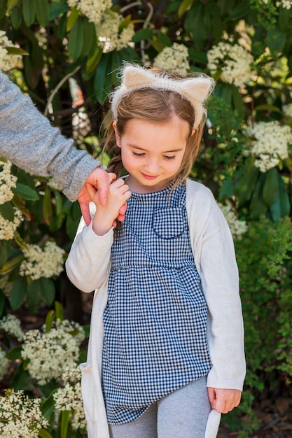 Adorable girl holding mother's hand