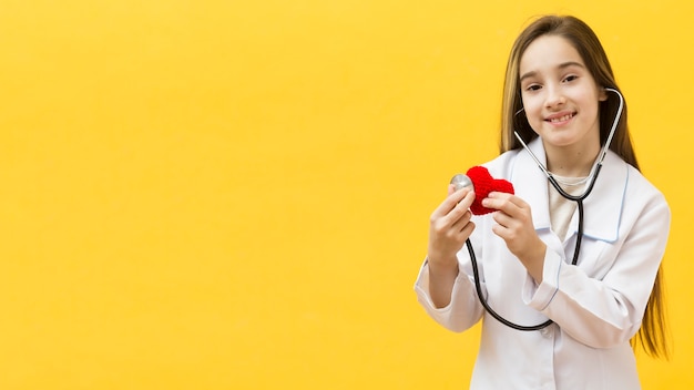 Adorable girl listening to heart copy space