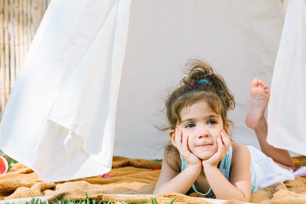 Adorable girl lying in tent