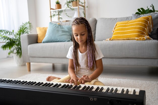 Adorable girl playing the piano at home