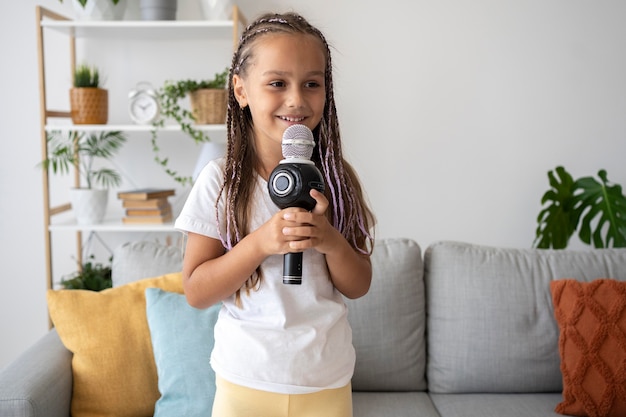 Очаровательная девушка поет в микрофон дома