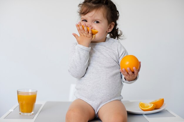 Adorable girl sitting and enjoying her oranges