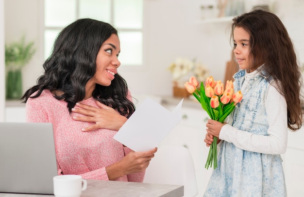 Mamma sorprendente della ragazza adorabile con i fiori