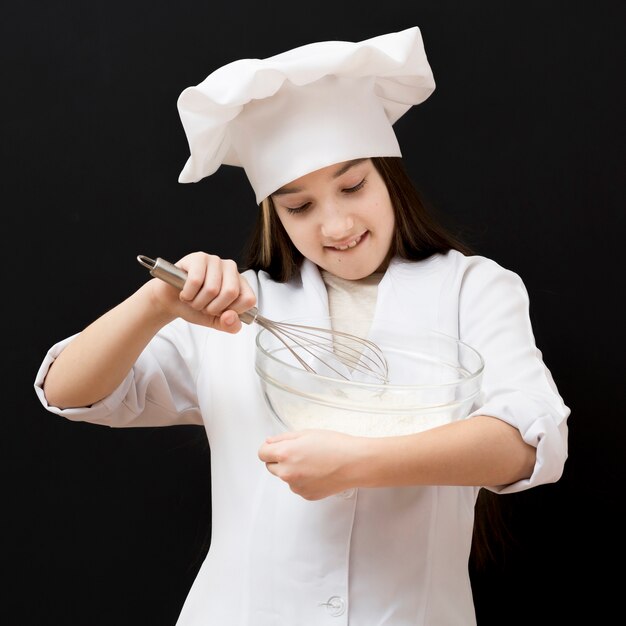 Adorable girl using whisk medium shot