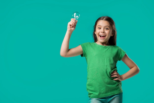 Adorable junior with lamp in studio