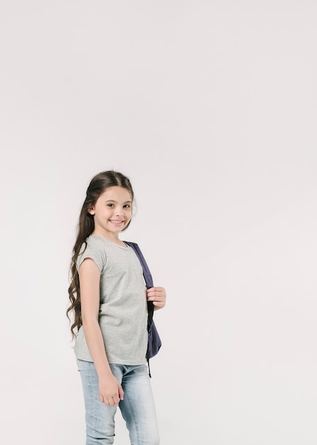 Adorable junior with schoolbag in studio