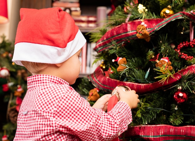 Adorable kid decorating a tree on christmas