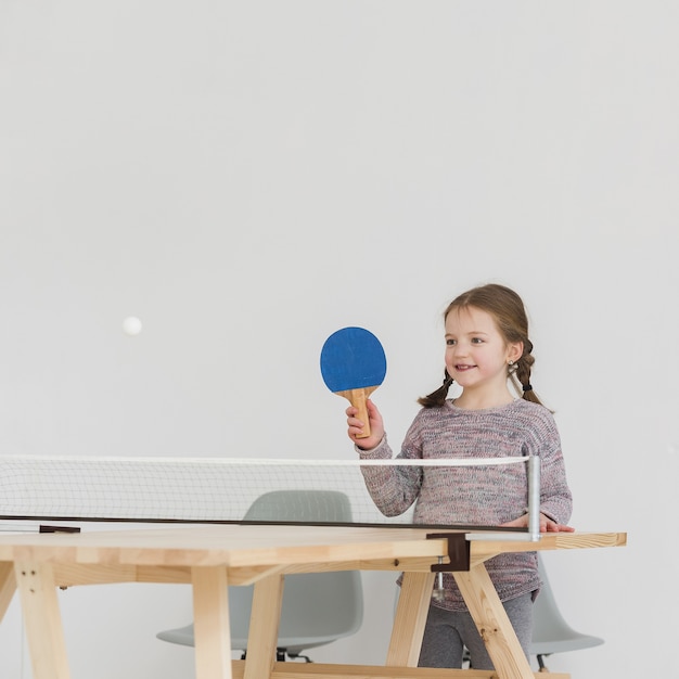 adorable kid playing ping pong indoors