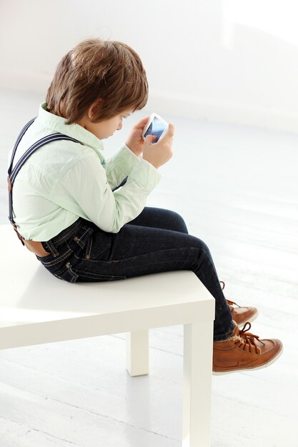 スマートフォンで遊ぶ愛らしい子供