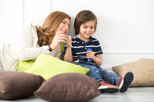 Adorable kid with mother making bubbles