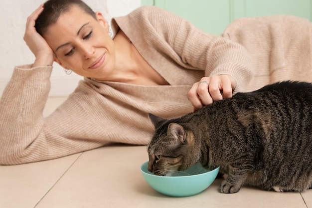 彼女の所有者の隣で食べる愛らしい子猫