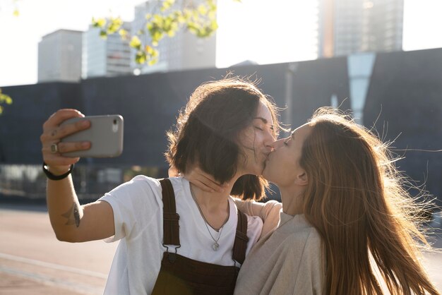 사랑스러운 레즈비언 커플 키스 옥외