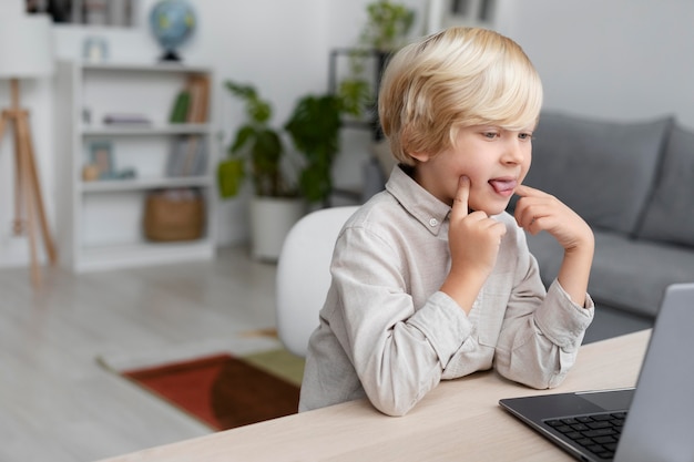 Adorable little boy doing an online session of speech therapy