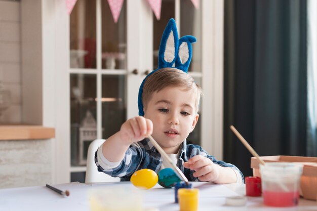 イースターのための愛らしい小さな男の子絵画卵