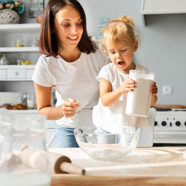 Adorable little girl and her mother cooking together
